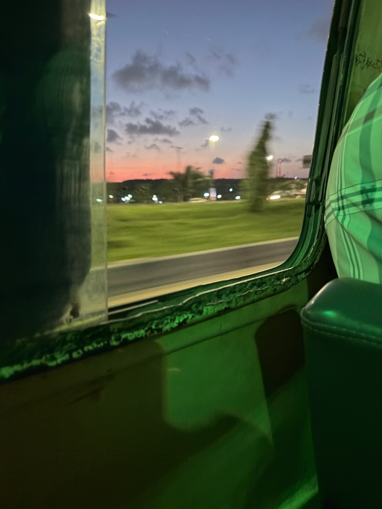 Green-lit danfo interior against dusk sky, Ojota