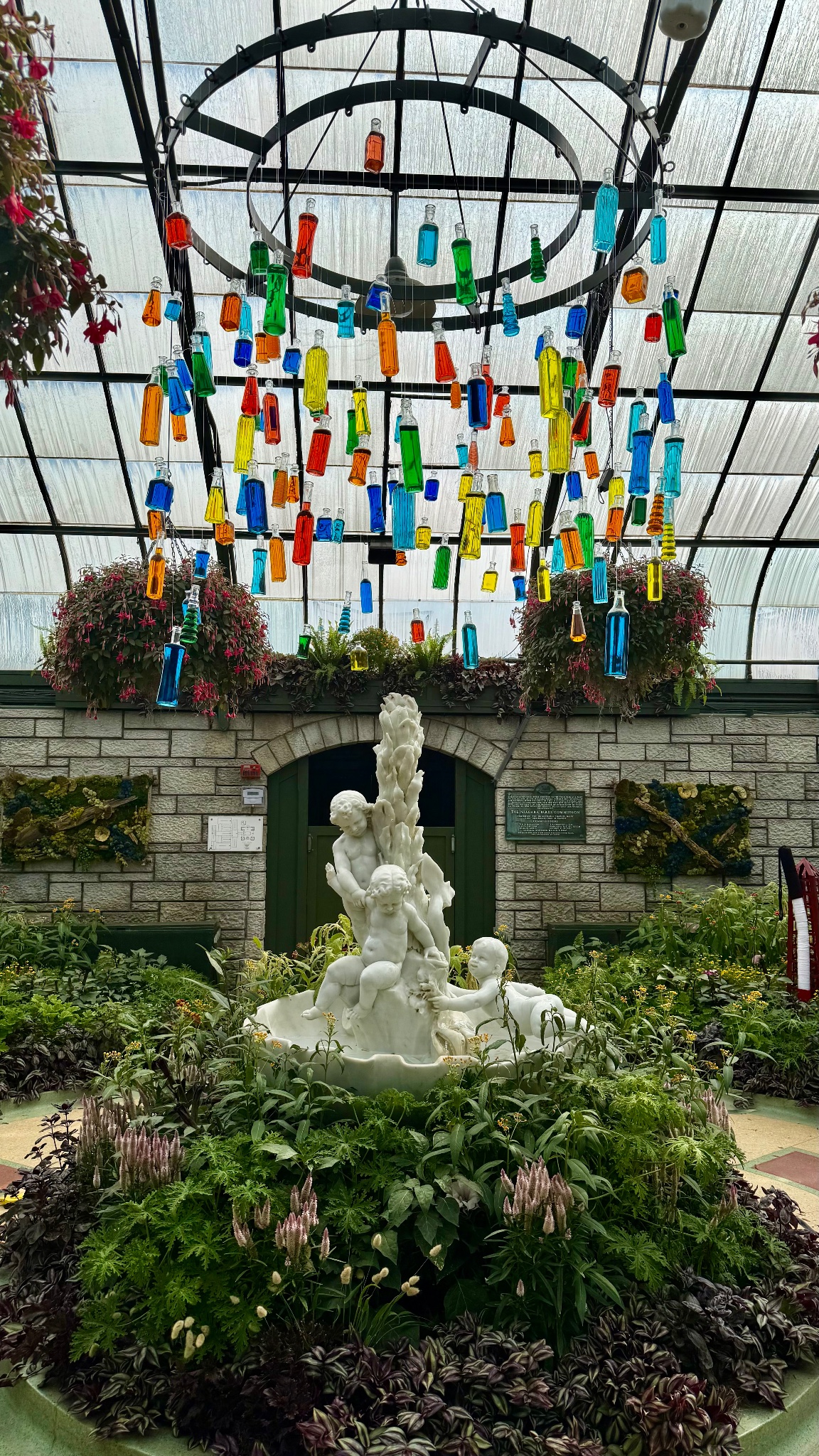Rainbow bottle chandelier over cherub fountain, Canada